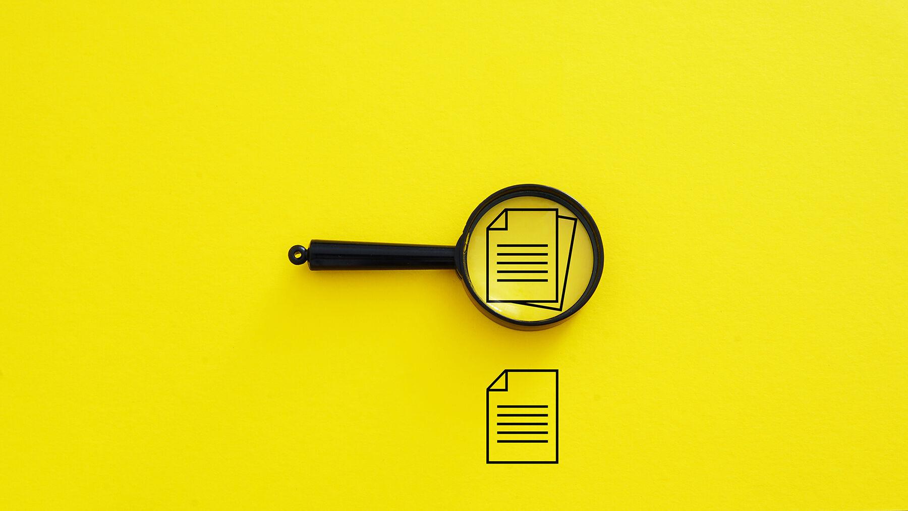 Magnifying glass over paper icons